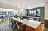 Modern kitchen with sleek marble island, elegant pendant lighting, and large windows offering abundant natural light.