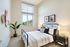 Bright and airy modern bedroom with a large window view, featuring chic decor and a cozy double bed with stylish bedding.