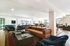 Chic communal living space showcasing modern leather sofas, rich decor, and panoramic windows for ample natural light.
