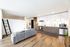 Bright, modern open-concept living space with sleek kitchen, cozy seating area, and stylish decor.