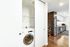 Modern apartment with sleek kitchen featuring stainless steel appliances and convenient in-unit washing machine, highlighted by warm wood flooring.
