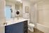 Elegant bathroom with modern vanity, integrated washer-dryer, and stylish shower curtain, perfect for convenient urban living.