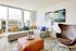 Bright and inviting living room with modern decor, floor-to-ceiling windows, and stylish furnishings including a plush sofa and leather chair.
