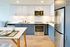 Modern kitchen with sleek cabinetry, stainless steel appliances, and elegant dining setup, perfect for culinary enthusiasts.