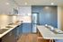 Modern kitchen with sleek gray cabinetry, stainless steel appliances, and a chic dining area, perfect for stylish living.