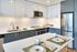 Modern kitchen design with sleek blue cabinets, stainless steel appliances, and stylish dining setup.