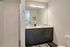 Elegant bathroom with modern dark vanity, large mirror, and sleek fixtures creating a luxurious atmosphere.