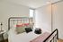 Bright and cozy bedroom with modern metal frame bed, chic throw pillows, and a sunlit window revealing a beautiful view, ideal for relaxation.