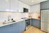 Modern kitchen featuring sleek grey and white cabinets, stainless steel appliances, and elegant wood flooring.