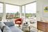 Bright and inviting living room with panoramic city views, featuring modern furniture and vibrant decor.