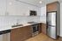 Sleek modern kitchen with stainless steel appliances, white cabinets, and chic wood accents.