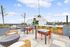 Stunning rooftop terrace with modern outdoor furniture, vibrant chairs, and lush greenery, perfect for relaxing and enjoying panoramic city views.