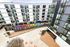 Vibrant urban apartment complex with colorful mural and modern architecture, featuring an inviting courtyard with seating.