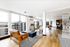 Bright and modern open-concept living area with stylish seating, panoramic city views, and elegant wooden flooring.