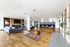 Luxurious open-concept lounge area showcasing stylish seating, modern fireplace, and chic dining space with decorative pendant lighting.