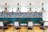 Chic dining area with elegant pendant lighting, tropical wallpaper, and modern teal seating, perfect for stylish gatherings.