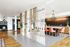Chic and modern apartment featuring a stylish woven room divider, vibrant chairs at a sleek kitchen island, and elegant pendant lighting.