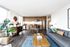 Modern open-plan living space with sleek kitchen, cozy seating, and abundant natural light from large windows.