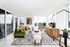 Bright and airy living room with stunning views, featuring a chic green sofa, contemporary art, and elegant modern decor. Perfect space for relaxation and entertaining.