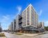 Modern urban apartment building with sleek design, ample natural light, and vibrant street view.