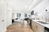 Modern studio apartment with sleek kitchen, cozy sleeping area, and abundant natural light.