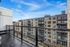 Modern apartment balcony view overlooking stylish urban architecture with vibrant facades and a clear blue sky.