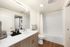 Sleek bathroom with modern fixtures, wood cabinetry, and in-unit laundry for ultimate convenience.