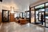 Contemporary lounge space with chic furnishings, natural light, and glass-walled meeting area in a vibrant apartment building.