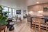 Contemporary apartment showcasing an open living area with floor-to-ceiling windows, cozy dining nook, modern kitchen, and elegant bedroom entrance.