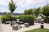 Chic rooftop patio with stylish seating, lush greenery, and a modern grill for outdoor entertaining.