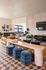 Contemporary living space with geometric tile flooring, plush leather seating, stylish art, and abundant natural light.