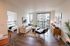 Bright and modern living room with sleek furnishings and large windows, adjacent to a cozy bedroom. A perfect blend of style and comfort in a chic apartment setting.