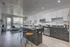 Modern apartment interior showcasing an open-concept kitchen and living area with sleek cabinetry, island seating, and abundant natural light from large windows.