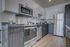 Modern kitchen with sleek stainless steel appliances, elegant cabinetry, and hardwood floors, creating a sophisticated ambiance.
