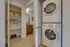Modern apartment featuring a sleek in-unit laundry area with a stacked washer and dryer, adjacent to a spacious pantry and a contemporary bathroom.