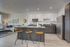 Modern open-concept kitchen and living room with sleek cabinetry, stylish island, and cozy seating area, bathed in natural light.