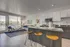 Contemporary open-plan living space featuring a sleek kitchen with modern appliances, a cozy living area with stylish decor, and abundant natural light from large windows.