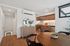 Modern kitchen and dining area with sleek wooden cabinetry, stainless steel appliances, and a chic round dining table.