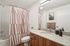 Contemporary bathroom with stylish striped shower curtain, sleek vanity, and modern fixtures, perfect for a chic apartment lifestyle.