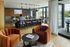 Elegant open-concept living area with modern furniture, warm lighting, and floor-to-ceiling windows offering scenic views.