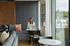 Modern apartment living room with cozy seating area, stylish decor, and large window offering scenic views.