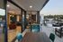 Luxurious apartment with open-plan living area leading to a spacious patio, stylish furniture, and scenic views.