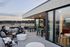 Chic rooftop terrace featuring cozy seating, modern decor, and expansive views of the surrounding landscape at sunset.