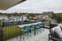 Chic rooftop patio with modern seating, offering picturesque views of a vibrant neighborhood and lush greenery.