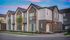 Charming modern townhomes with stylish exteriors, featuring large windows and vibrant curb appeal under a colorful twilight sky.