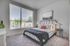 Bright and modern bedroom with a large window, cozy bed, and stylish decor for a peaceful retreat.