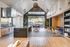 Chic open-concept kitchen and dining area with high ceilings, modern fixtures, and elegant wooden accents.