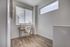 Bright home office with sleek wooden desk, cozy fur chair, and expansive windows offering natural light.