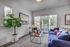 Bright and modern living room with a cozy blue sofa, stylish coffee table, and large window bringing in natural light.