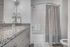 Sleek modern bathroom featuring a granite countertop, elegant fixtures, and a stylish striped shower curtain.